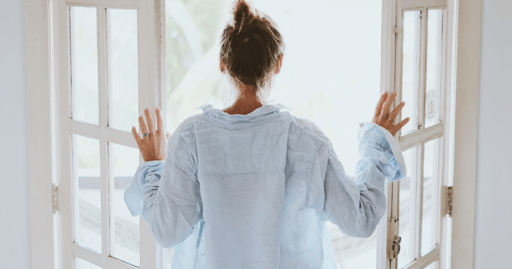 寝起きに朝日を浴びる女性の姿